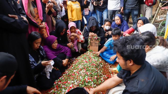 Keluarga dan pelayat berdoa di atas pusara Agung Yulianto alias Ki Joko Bodo di TPU Kober, Lubang Buaya, Jakarta Timur, Selasa (22/11/2022). [Semujer.com/Alfian Winanto]