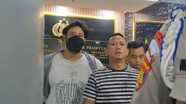 Ammar Zoni (mengenakan masker) saat keluar dari Polres Metro Jakarta Barat untuk melakukan pemeriksaan urine, Kamis (14/12/2023). [YouTube Intens Investigasi]